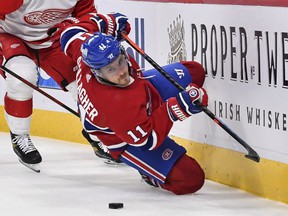 Brendan Gallagher of the Montreal Canadiens falls while skating with the puck against Nick Leddy of the Detroit Red Wings during the second period at the Bell Center on October 23, 2021.