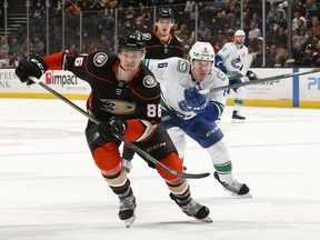 Simon Benoit of the Anaheim Ducks and Brock Boeser of the Vancouver Canucks battle for position during the second period at the Honda Center on Sunday.