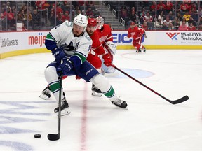 JT Miller, foreground, of the Vancouver Canucks fights for the puck against Filip Hronek of the Red Wings at Little Caesars Arena on October 16 in Detroit.