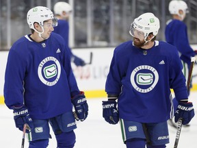 Quinn Hughes (left) and Conor Garland are having different fortunes when it comes to participating in the Canucks' first-unit power play.