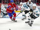 Canadiens 'Nick Suzuki chases puck along with San Jose Sharks' Logan Couture, Jacob Middleton and Jonathan Dahlen during the first period in Montreal on October 19, 2021. 