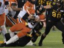 CP-Web.  BC Lions quarterback Michael Reilly is fired by Hamilton Tiger Cats defensive end Julian Howsare (95) during first half action of a CFL football game in Hamilton, Ontario.  on Friday, November 5, 2021.