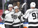 Los Angeles Kings forward Trevor Moore (12) celebrates with defender Tobias Bjornfot (left) and forward Carl Grundstrm after scoring against his former team Maple Leafs in the first period at Scotiabank Arena on Monday, November 11, 2021. 