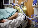 Respiratory therapist Flor Guevara adjusts a breathing tube for a patient suffering from COVID-19 in the Intensive Care Unit at Humber River Hospital in Toronto on April 29, 2021.