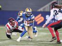 Winnipeg Blue Bombers wide receiver Janarion Grant (80) evades a tackle by Montreal Alouettes defensive back Adarius Pickett (6) during the third quarter during a Canadian Soccer League game at IG Field.  The Winnipeg Blue Bombers defeat the Montreal Alouettes 31-21. 