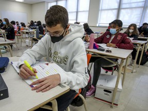Masked students work at their desks during French class at John F. Kennedy High School in Montreal in 2020. Starting November 15, 2021, they can go without a mask in class.