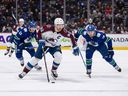 Colorado Avalanche's Gabriel Landeskog skates with the puck as Vancouver Canucks' Tanner Pearson chases him in the first period. 