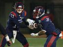 Montreal Alouettes quarterback Trevor Harris surrenders to Alouettes running back William Stanback as they face the Ottawa Redblacks during first-quarter CFL football action in Montreal on Friday, Nov. 19, 2021.