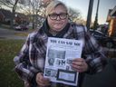Bronwyn Greenacre holds up a flyer against the vaccines she received outside of her children's school, Tuesday, Nov. 23, 2021.