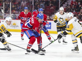Canadiens 'Brendan Gallagher has the puck pushed by Pittsburgh Penguins' Teddy Blueger, left, and Michael Matheson in Montreal on November 18, 2021.