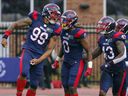 Jamal Davis II of Montreal Alouettes celebrates the firing of Caleb Evans from the Ottawa Redblacks with teammates Brian Harelimana (0), Ahmad Thomas and Chris Ackie in Montreal on October 11, 2021. 
