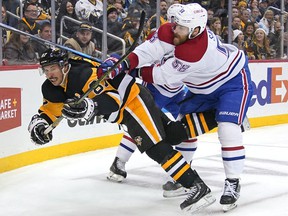 Sidney Crosby (87) of the Penguins is stopped on ice by David Savard (58) of the Canadiens in Pittsburgh on Saturday, November 27, 2021.