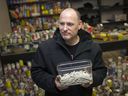In this 2018 file photo, Leo Lucier, owner of Compassion House, holds a container full of rolled marijuana joints.  Banned from selling marijuana, the local marijuana activist was giving it away in exchange for charitable donations.