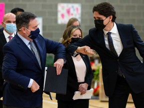 Prime Minister Justin Trudeau (right) and Alberta Prmier Jason Kenney bump elbows during a joint federal-provincial ad for a $ 10-a-day daycare at Boyle Street Plaza in Edmonton, Monday, Nov. 15, 2021.