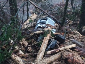 A vehicle buried in debris in one of the landslides on Hwy. 7.