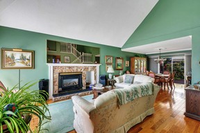 A vaulted ceiling and a stone surround gas fireplace in the living room.