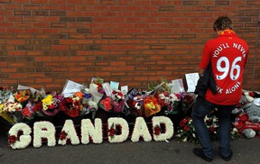 A fan pays his respects outside Anfield to the 96 fans who died in the Hillsborough disaster in 1989 before the English Premier League soccer match between Liverpool and Manchester United at Anfield in Liverpool on 23 September 2012. AFP PHOTO / PAUL ELLIS