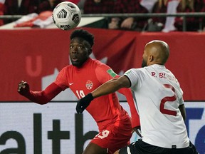 Alphonso Davies of Team Canada, left, and Ricardo Blanco of Team Costa Rica, battle for the ball during a 2022 FIFA World Cup qualifying soccer match at Commonwealth Stadium in Edmonton on Friday, Nov. 12, 2021 .