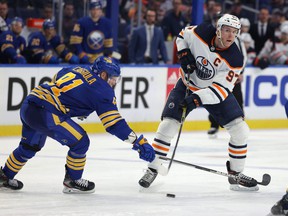 Buffalo Sabers center Drake Caggiula (91) attempts to block a pass from Edmonton Oilers center Connor McDavid (97) during the third period at the KeyBank Center on November 12, 2021.