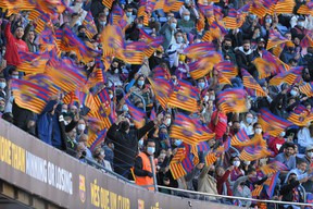 FC Barcelona supporters wave club flags from the stands, before the official presentation ceremony of the new Spanish FC Barcelona coach, Xavi Hernández, at the Camp Nou stadium in Barcelona on November 8, 2021 (Photo by LLUIS GENE / AFP).