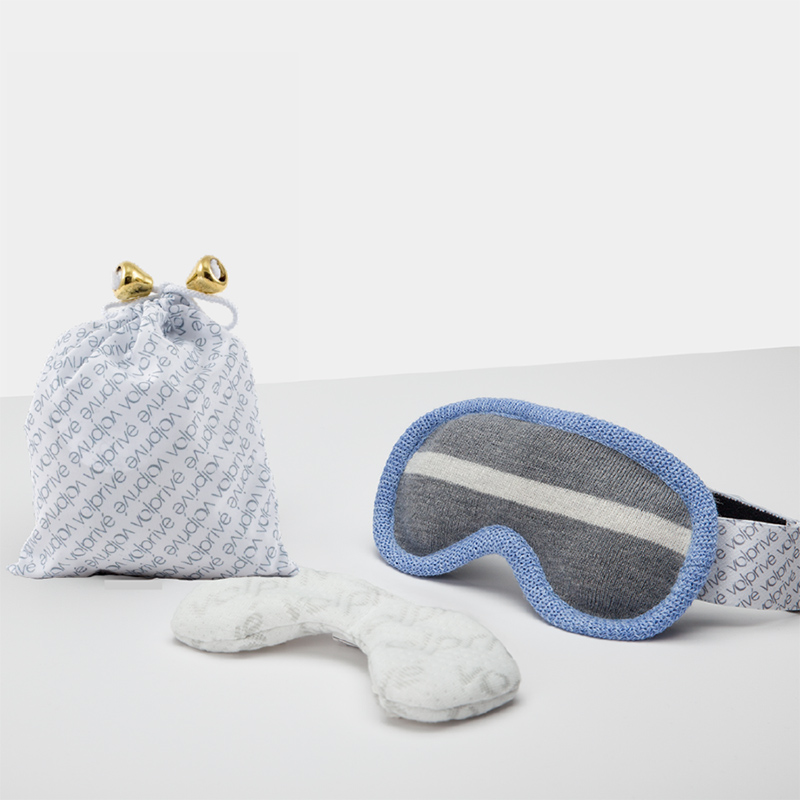 A blue and gray sleep mask with a white patterned bag