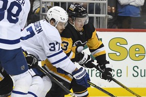 Timothy Liljegren of the Maple Leafs and Brock McGinn of the Pittsburgh Penguins battle for the puck during the second period of an NHL hockey game on Saturday, Oct. 23, 2021, in Pittsburgh, Pennsylvania.