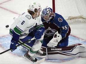 Vancouver Canucks right wing Brock Boeser collides with Colorado Avalanche goalie Darcy Kuemper during the first period of an NHL hockey game Thursday, November 11 in Denver.