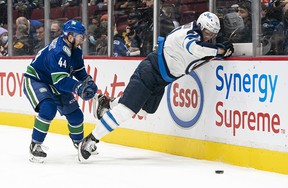 Vancouver Canucks 'Kyle Burroughs controls Winnipeg Jets' Evgeny Svechnikov on the boards in the first period at Rogers Arena on Friday night.