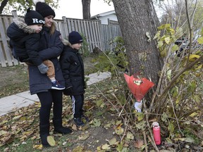 Amanda Lapier and her two children, Alexandros, 3, and Lucas, 8, left flowers and a candle at the scene of an accident that killed a five-year-old girl at Renforth Dr.