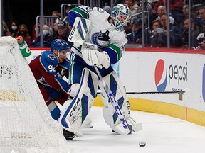 Canucks goalkeeper Thatcher Demko controls the puck under pressure from Colorado Avalanche left winger Gabriel Landeskog at Ball Arena.  His teammates hung him up to dry in a sobering loss in Denver.