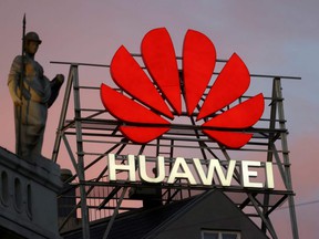 The logo of Chinese telecommunications giant Huawei Technologies is displayed next to a statue on top of a building in Copenhagen, on June 23, 2021.