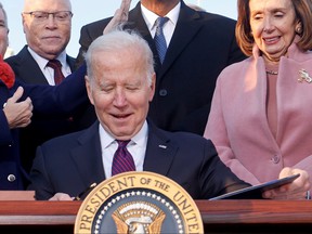 United States President Joe Biden celebrates with lawmakers, including House Speaker Nancy Pelosi, before signing the Infrastructure Investment and Employment Act on the South Lawn of the White House in Washington, DC , on November 15, 2021.