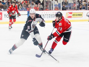 Vancouver Giants winger Zack Ostapchuk tries to block a shot from Portland Winterhawks defender Luca Cagnoni on Wednesday in Portland.