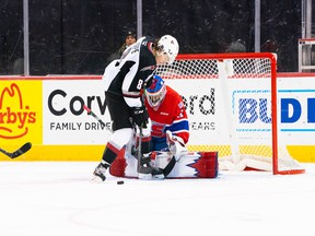Vancouver Giants forward Ty Thorpe tries to get one from Spokane Chiefs goalkeeper Manny Panghli in Spokane on Saturday.