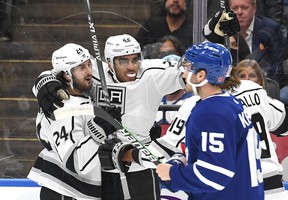 Los Angeles Kings forward Andreas Athanasiou (22) celebrates with forwards Phillip Danault (left) and Alex Iafallo (hidden) after scoring against the Maple Leafs in the first period at Scotiabank Arena on Monday, Nov. 11, 2021.