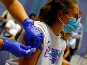 Tatiana Suarez, a 15-year-old resident of Gran Canaria, Spain, receives a dose of the COVID-19 vaccine.