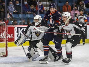 Mazden Leslie (right) of the Giants and Logan Bairos of the Kamloops Blazers compete for a position against Vancouver netinder WIll Gurski last month.