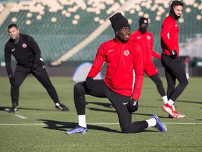 Alphonso Davies stretches during Canada men's national soccer team practice ahead of the 2022 FIFA World Cup qualifying game with Costa Rica on Friday.  Taken Wednesday, November 10, 2021, at Commonwealth Stadium in Edmonton.