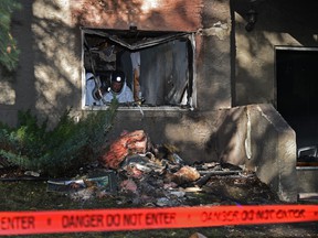 Fire investigators at the scene of a nighttime fire that appears to have started on the main floor of Sandlewood Place Apartments 6504 129 Ave. in Edmonton, September 23, 2021.