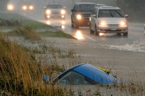 A car lies submerged in a ditch on a flooded stretch of road in Chilliwack.