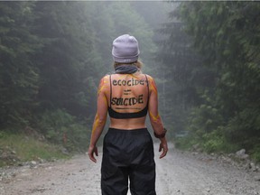A woman stands near a protesters blockade against logging in the Fairy Creek area of ​​Vancouver Island near Port Renfrew on May 24, 2021.
