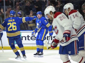 Sabers 'Kyle Okposo and defender Rasmus Dahlin celebrate after Okposo's goal during the second period as Candiens' Chris Wideman and Nick Suzuki, right, skate away.