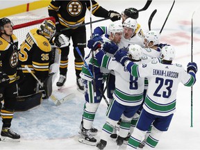 Vancouver Canucks' Tanner Pearson (70) celebrates his goal with teammates Brock Boeser (6), Conor Garland (8), Oliver Ekman-Larsson (23) and Nils Hoglander (21) during the first period of a hockey game for the NHL vs. Boston.  Bruins, Sunday, Nov. 28, 2021, in Boston.