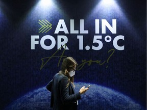 A delegate walks past a poster during the United Nations Climate Change Conference (COP26) in Glasgow, Scotland, Great Britain, on November 11, 2021.