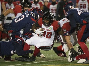 Ottawa Redblacks running back Timothy Flanders is tackled by Montreal Alouettes defensive back Patrick Levels during first-quarter CFL football action in Montreal on Friday, Nov. 19, 2021.