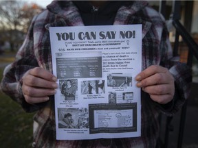 Bronwyn Greenacre holds up a flyer against the vaccines she received outside of her children's school, Tuesday, Nov. 23, 2021.