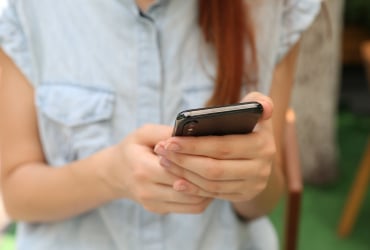 Hands holding a cell phone.