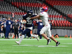 GW Graham running back Sam Mannes carries the ball as Centennial defensive back Ziad Sabry tries to tackle it on Saturday, Nov. 28, 2021 at BC Place.  GW Graham won the Triple A semifinal 19-0.
