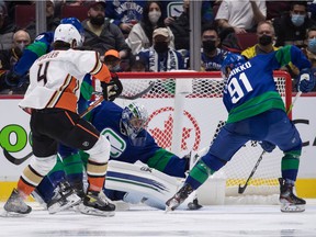 Vancouver Canucks goalkeeper Jaroslav Halak, back, from Slovakia, stops Anaheim Ducks' Cam Fowler (4) when Juho Lammikko (91), from Vancouver, Finland, reaches the puck during the second period of the game of the Tuesday at Rogers Arena.