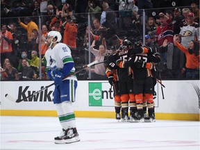 Anaheim Ducks players celebrate after a goal scored by center Trevor Zegras (46) during the first period as Vancouver Canucks right wing Justin Bailey (95) skates at the Honda Center.